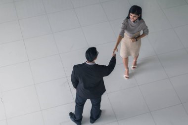 Patron ve sekreter selamlaşmak için el sıkışıyorlar. 