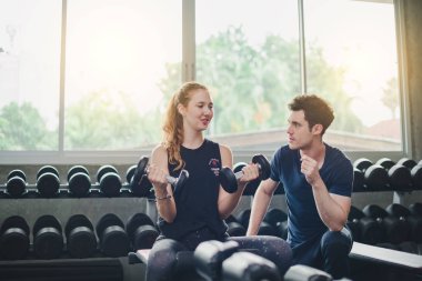 Güzel bir kadın egzersiz ve spor yapıyor. Antrenör veriyor.