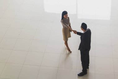 Patron ve sekreter selamlaşmak için el sıkışıyorlar. 