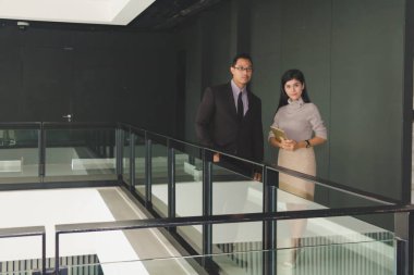 Yöneticiler ve sekreterler kapalı koridorlarda yürüyorlar.