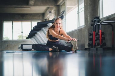 Güzel bir sporcu bir takım elbise giydi. Bir kas üzerinde gerinme