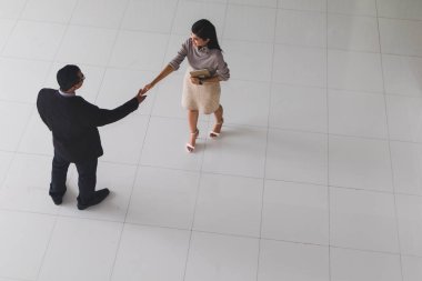 Patron ve sekreter selamlaşmak için el sıkışıyorlar. 