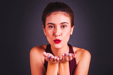 Kırmızı elbiseli güzel bir Asyalı kız GR 'ın önünde duruyor.