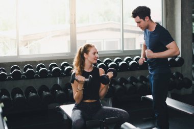 Güzel bir kadın egzersiz ve spor yapıyor. Antrenör veriyor.