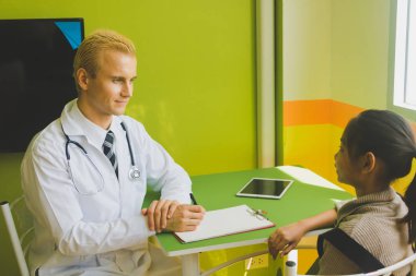 Doktor hasta çocuğu muayene ediyor.