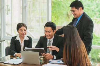 Yöneticiler ve çalışanlar iş yerinde iş konuşuyorlar.