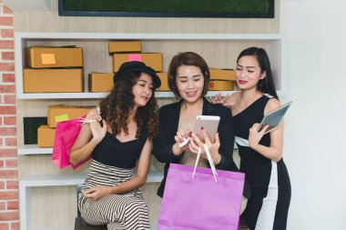 Asyalı kız internette alışveriş yapıyor. Telefon ve kredi kartıyla. Ne?