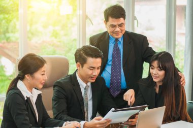 Yöneticiler ve çalışanlar iş yerinde iş konuşuyorlar.