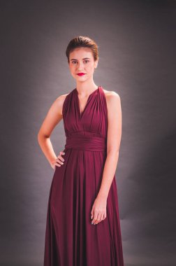 Kırmızı elbiseli güzel bir Asyalı kız GR 'ın önünde duruyor.