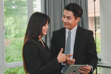 Yöneticiler ve sekreterler ofiste iş konuşuyorlar..