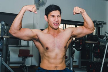 Asyalı kaslı adamlar spor salonunda ağırlık kaldırıyor..