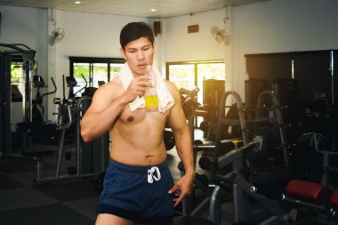 Asyalı adam spor salonunda kas egzersizi yapıyor. Ve Asyalı yakışıklı bir müzisyen.