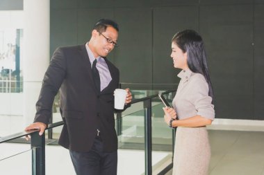 Yöneticiler ve sekreterler kapalı koridorlarda yürüyorlar.