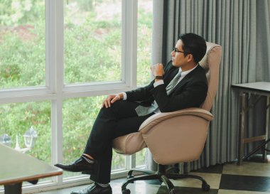 Genç Asyalı İş Adamı Koltuğu dinleniyor. Ve dikkat et