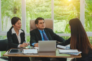 Yöneticiler ve çalışanlar iş yerinde iş konuşuyorlar.