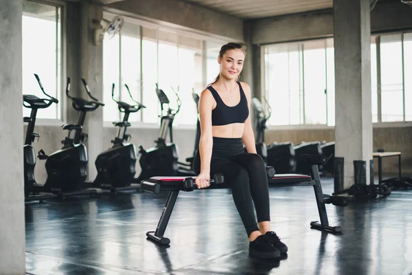 Güzel beyaz kız, halteri kaldırarak egzersiz yapıyor. 