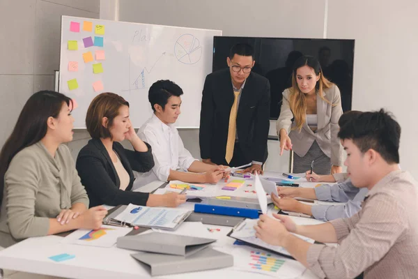 Bir grup Asyalı iş adamı işlerini tartışıyor.