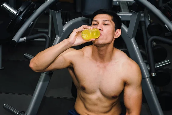 Asian man has muscle exercise in the gym.And he are tired, so dr