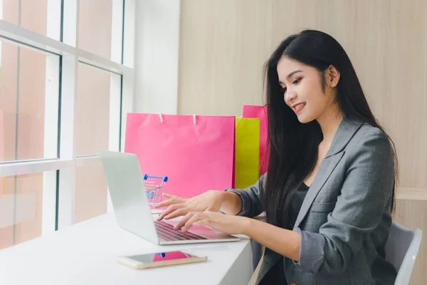 亚洲女孩坐在网上购物。通过电话和信用卡。哈 — 图库照片