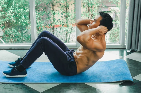 Aziatische mannen met mooie spieren doen sit-ups — Stockfoto