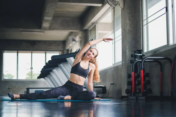 Güzel bir sporcu bir takım elbise giydi. Bir kas üzerinde gerinme