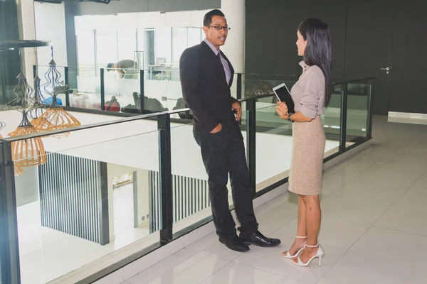 Yöneticiler ve sekreterler kapalı koridorlarda yürüyorlar.