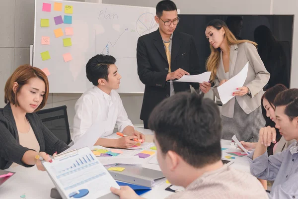 Bir grup Asyalı iş adamı işlerini tartışıyor.
