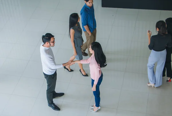 Azjatyccy pracownicy biurowi uścisną sobie dłonie, by się przywitać. — Zdjęcie stockowe