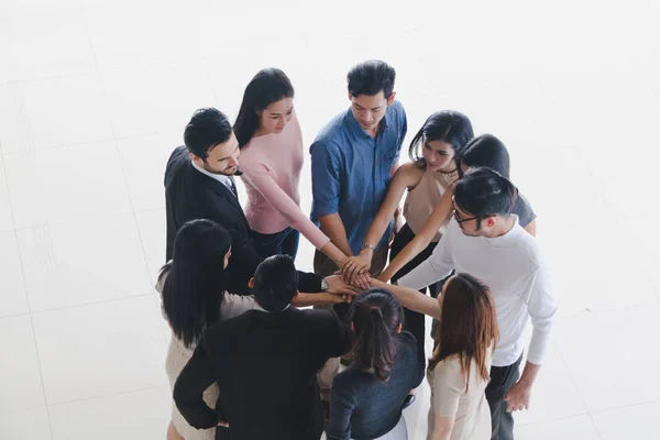 Male and female businessmen join hands in the hall of office.Top