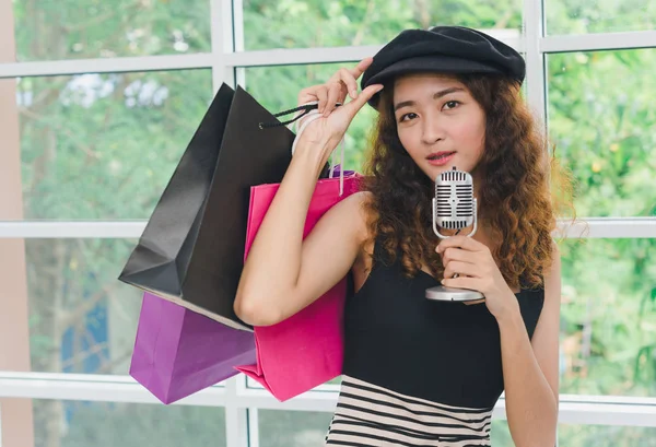 Азійська дівчина за покупками використовує мікрофон для співу. Купівля конуса — стокове фото