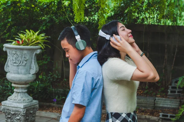 Сестра і брат слухають музику в саду. — стокове фото