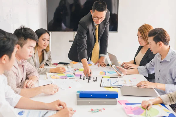 Bir grup Asyalı iş adamı işlerini tartışıyor.