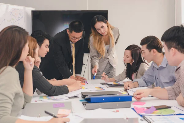 En gruppe asiatiske forretningsmenn diskuterer arbeidet sitt. Presi. – stockfoto