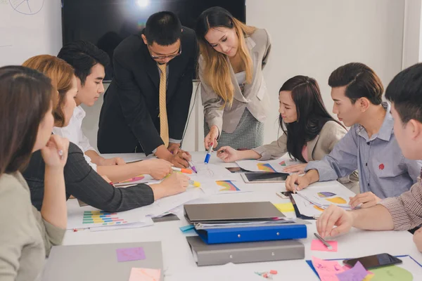 Bir grup Asyalı iş adamı işlerini tartışıyor.