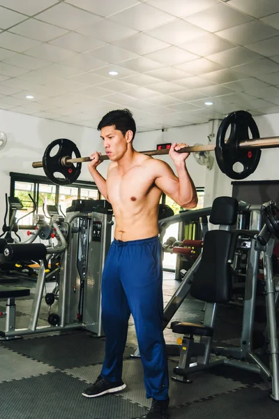 Asiatische muskulöse Männer stemmen Gewichte im Fitnessstudio. — Stockfoto