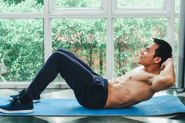 Asiáticos homens com belos músculos estão fazendo sit-ups — Fotografia de Stock