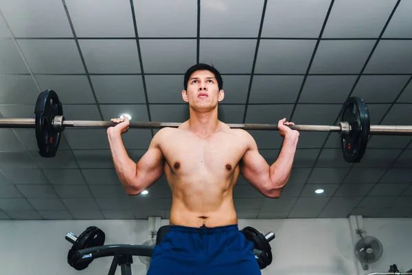 Asiatische muskulöse Männer stemmen Gewichte im Fitnessstudio. — Stockfoto