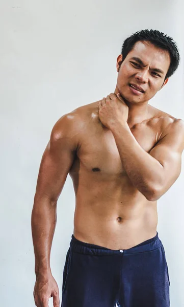 Asiatischer Mann mit muskulärer Nackenverletzung bei Übung auf weißem Rücken — Stockfoto
