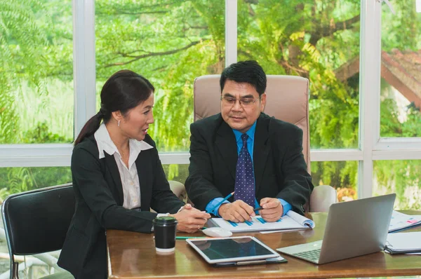 Yöneticiler ve sekreterler ofiste iş konuşuyorlar..