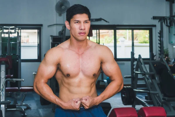 Asiatische muskulöse Männer stemmen Gewichte im Fitnessstudio. — Stockfoto