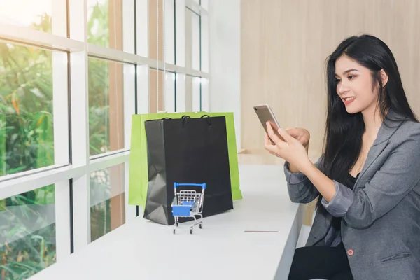 Menina asiática sentado compras online. Por telefone e cartão de crédito. Sim. — Fotografia de Stock