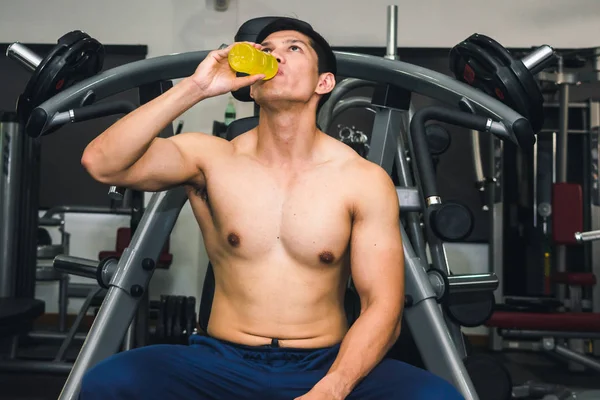 Hombre asiático tiene ejercicio muscular en el gimnasio.Y él está cansado, así que dr — Foto de Stock