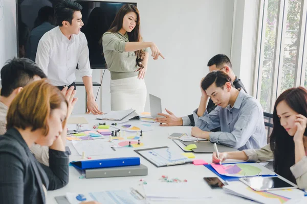 Bir grup Asyalı iş adamı tartışıyorlar. Çalışanlar ön plandadır.