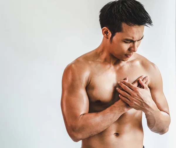 Asian man with muscular Injury to the chest from exercise on Whi — ストック写真