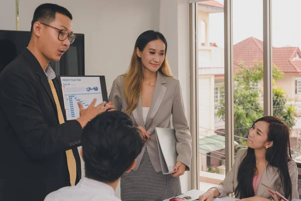 Bir grup Asyalı iş adamı işlerini tartışıyor.