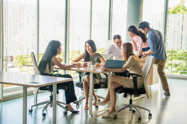 Asyalı bir ofis çalışanı iş yerinde rahat bir toplantıda oturuyor..