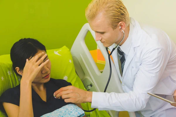 Médico y enfermera están escuchando el corazón mediante el uso de un sethoscop —  Fotos de Stock