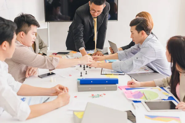 Bir grup Asyalı iş adamı işlerini tartışıyor.