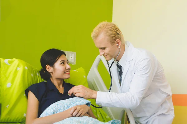 Médico y enfermera están escuchando el corazón mediante el uso de un sethoscop —  Fotos de Stock