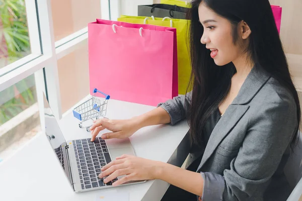 亚洲女孩坐在网上购物。通过电话和信用卡。哈 — 图库照片